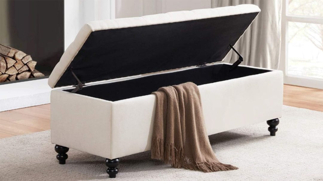 white ottoman blanket box with the lid open and a brown blanket falling out